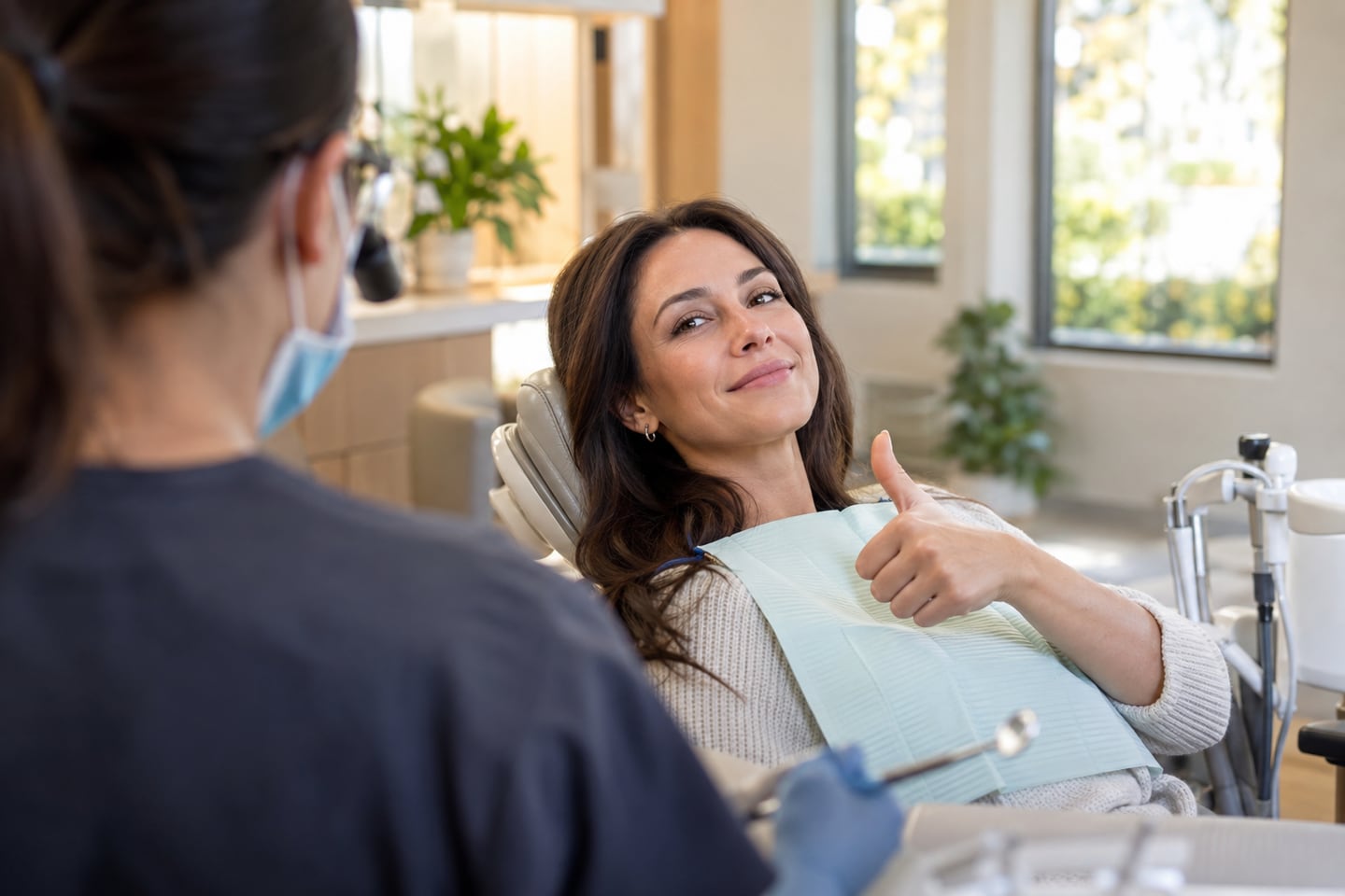 A relaxed patient giving a thumbs-up from the dental chair.