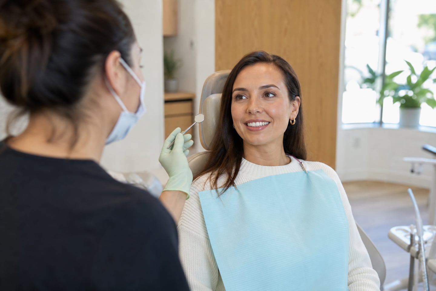 A dentist calmly examining a patient who has come in with tooth pain.