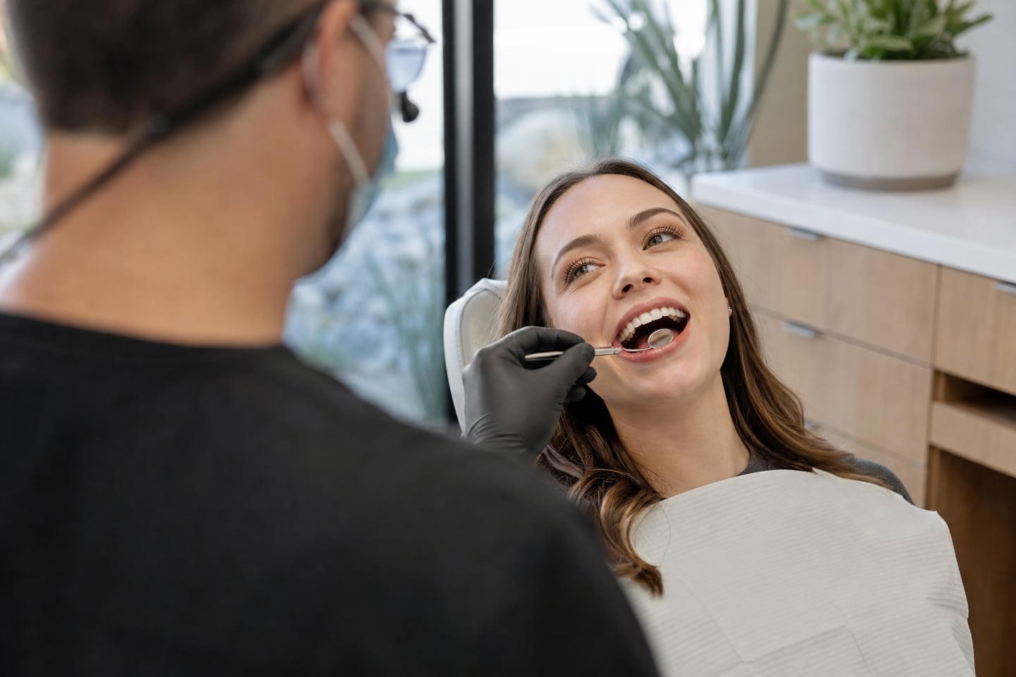 A dentist examining a relaxed patient's teeth during a routine check-up.