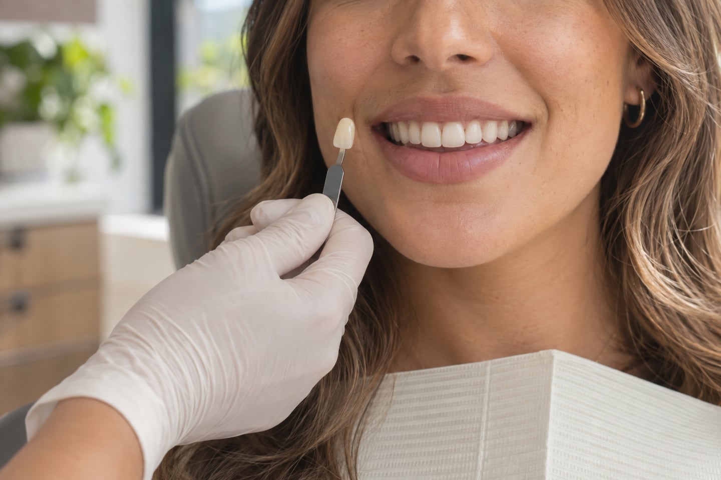 A shade guide held beside a patient's smile to compare tooth colour.