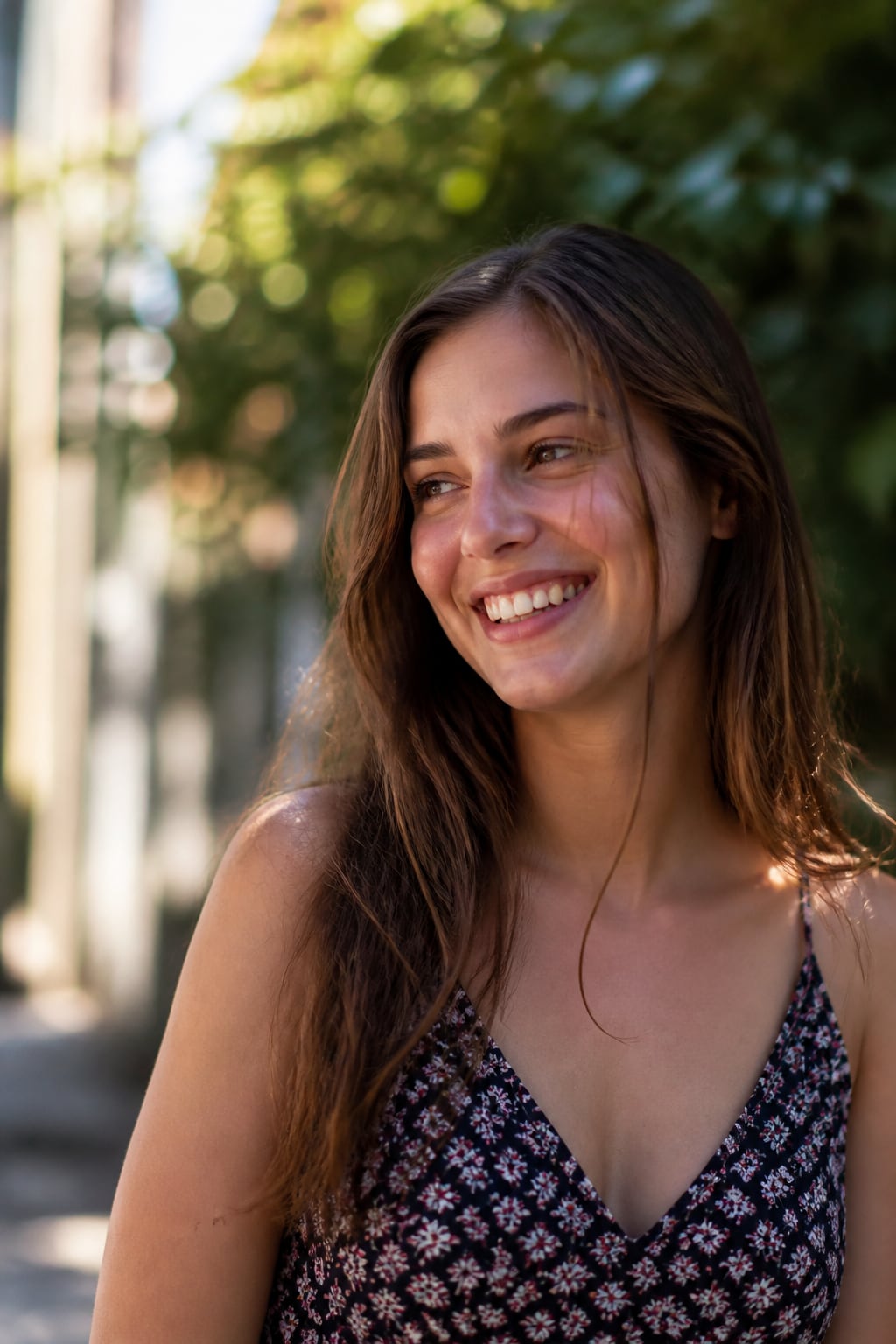 A young adult laughing naturally outdoors.