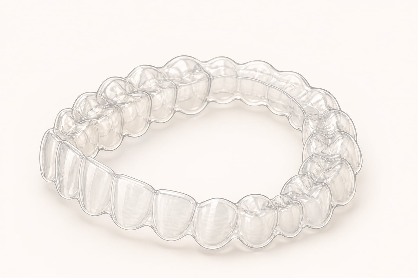 Illustration of a clear removable orthodontic aligner tray shown alone at an angle, moulded to the shape of an upper arch with a thin scalloped edge following the gum line.